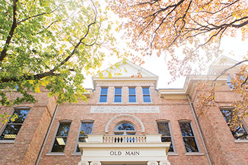 Photo of a student riding her bicycle in front of a campus building. Link to Gifts of Real Estate.